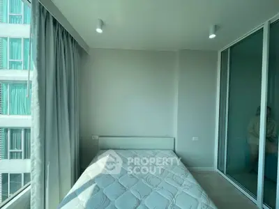 Modern bedroom with large windows and minimalist design in a high-rise apartment.