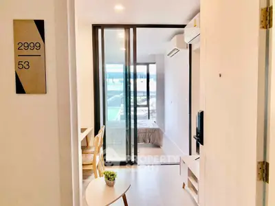 Modern apartment interior with bedroom and living area, featuring sleek design and natural light.