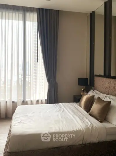 Luxurious bedroom with elegant decor and large window offering city views