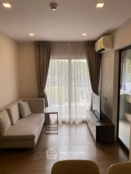 Modern living room with natural light, cozy sofa, and balcony view in a stylish apartment.