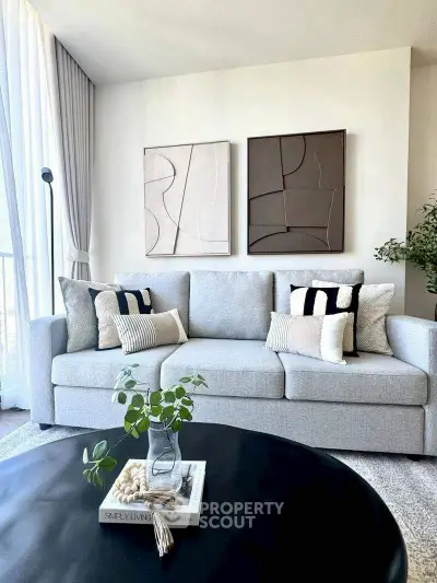 Modern living room with stylish grey sofa and abstract wall art, perfect for contemporary homes.