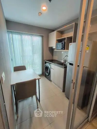Modern kitchen with sleek appliances and dining area in compact layout