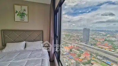 Stunning bedroom with panoramic city view from large window in modern high-rise apartment.
