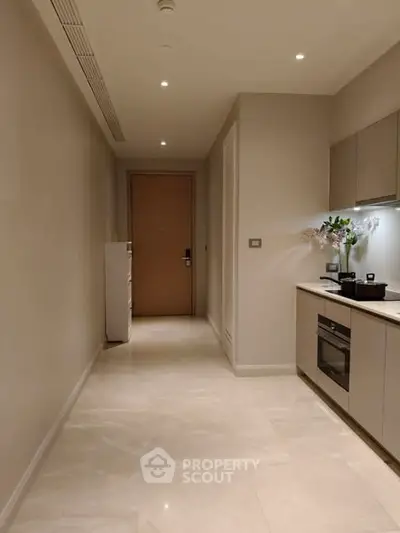 Modern kitchen with sleek cabinetry and built-in oven in a stylish apartment