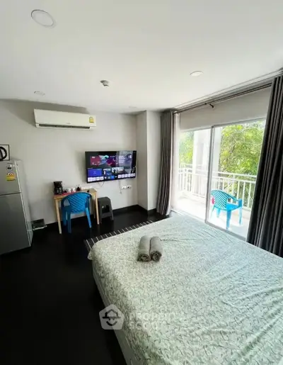 Modern bedroom with balcony access and wall-mounted TV in a stylish apartment.