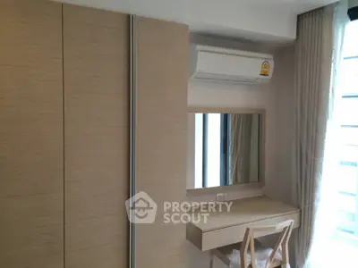 Modern bedroom with built-in wardrobe and air conditioning unit, featuring a sleek vanity desk and chair.