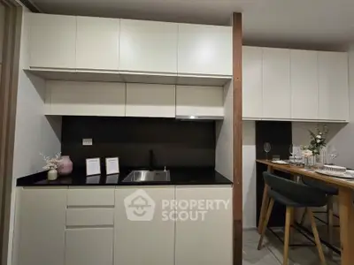 Modern kitchen with sleek cabinetry and breakfast bar in stylish apartment