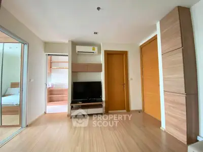Modern living room with wooden flooring and sleek furniture in a cozy apartment.