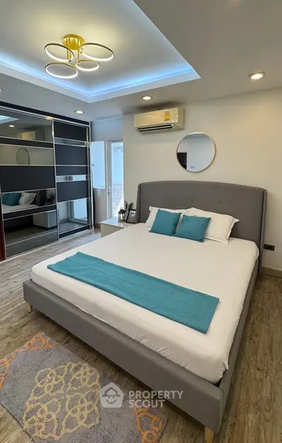 Modern bedroom with stylish decor, featuring a comfortable bed, mirrored wardrobe, and elegant lighting.