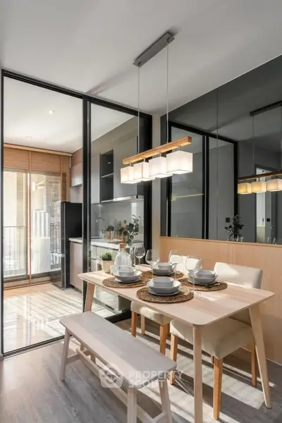 Modern dining area with elegant table setting and glass partition leading to a stylish kitchen.