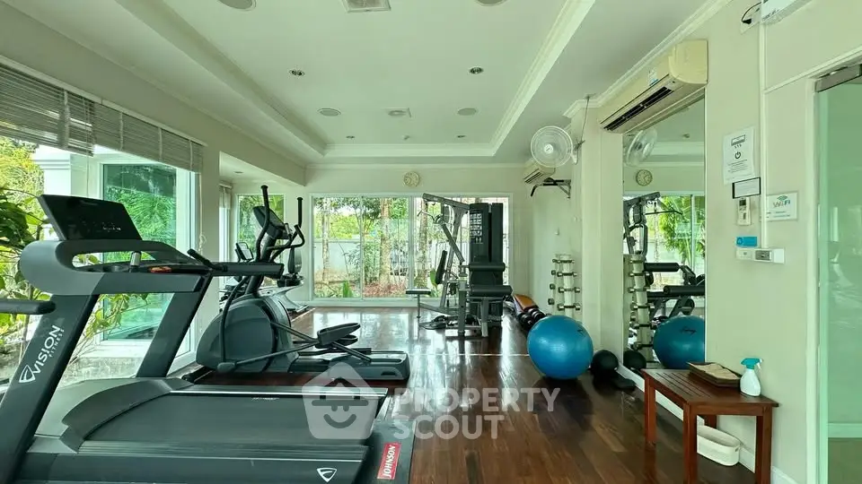 Spacious home gym with modern equipment and large windows for natural light