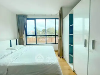 Bright and spacious bedroom with large windows and modern furnishings.