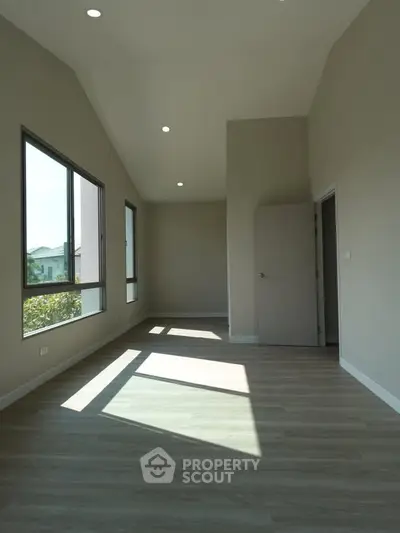 Spacious modern room with large windows and natural light, perfect for a bright living space.