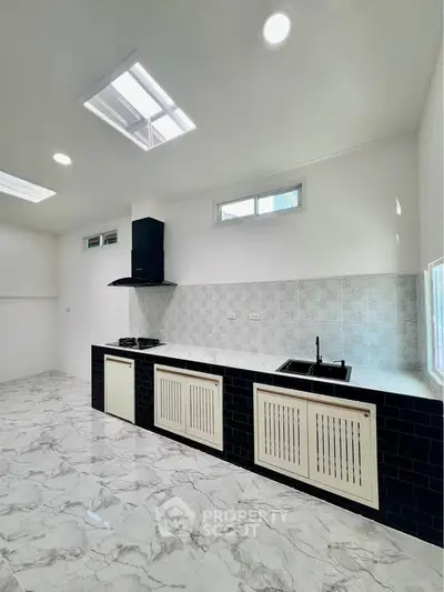 Modern kitchen with marble flooring and sleek black and white cabinetry
