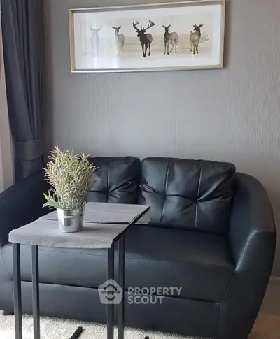 Stylish living room with black leather sofa and modern decor, perfect for cozy relaxation.