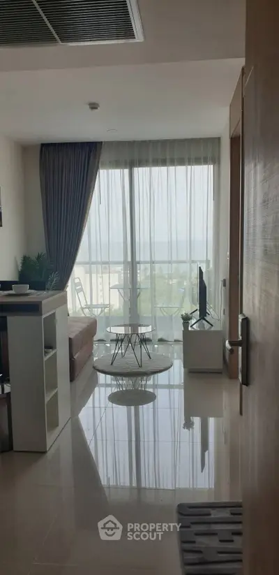 Modern living room with large windows offering a stunning view, sleek furniture, and elegant decor.