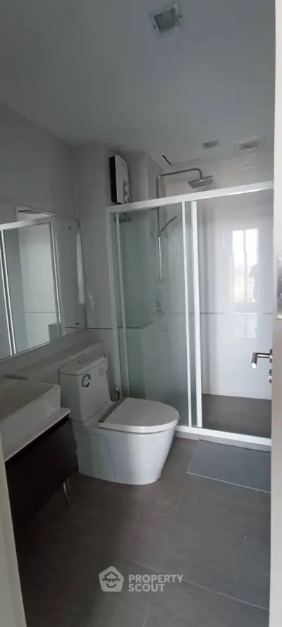 Modern bathroom with glass shower and sleek fixtures in a contemporary apartment.