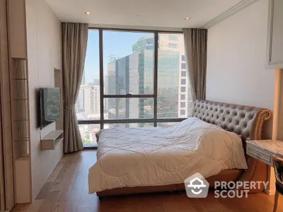 Luxurious bedroom with city view and elegant decor in modern high-rise apartment.