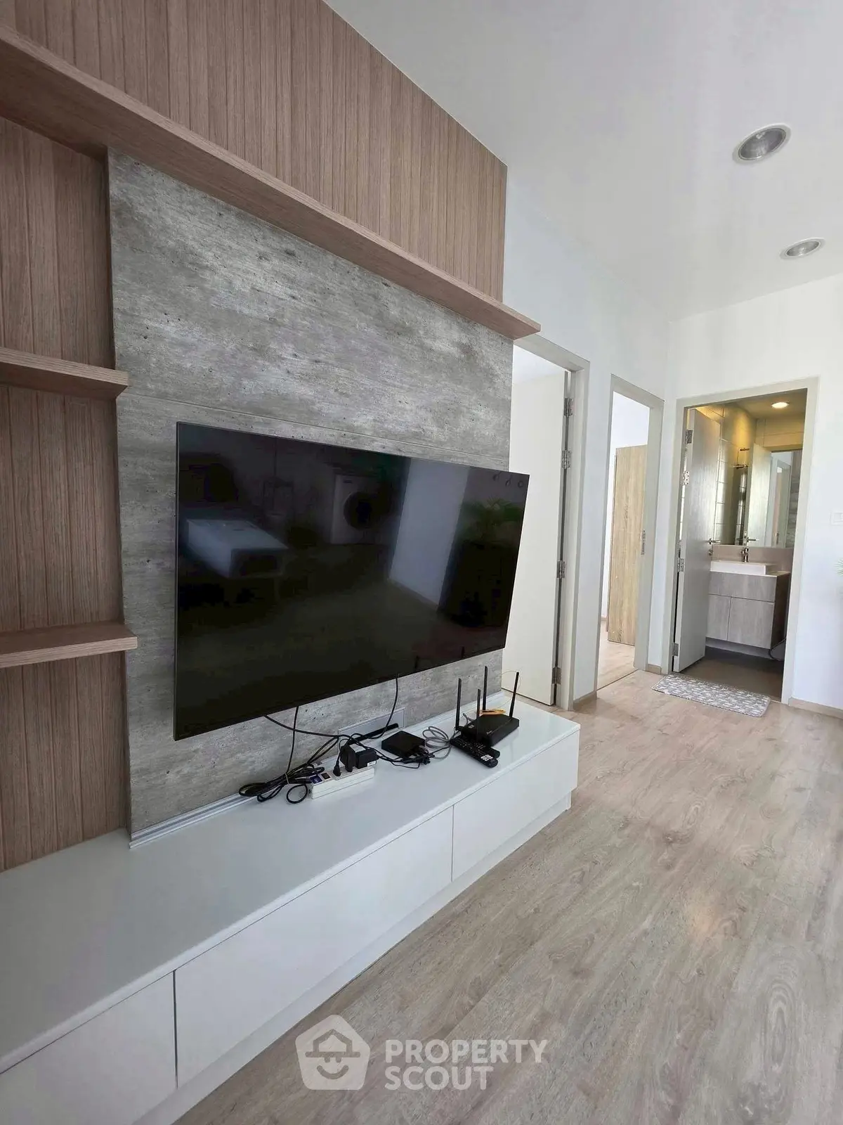 Modern living room with sleek TV setup and stylish wooden accents