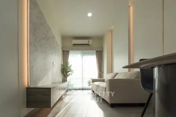 Modern living room with natural light, sleek furniture, and elegant decor.
