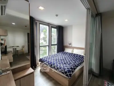 Modern bedroom with large windows and stylish decor in a cozy apartment.