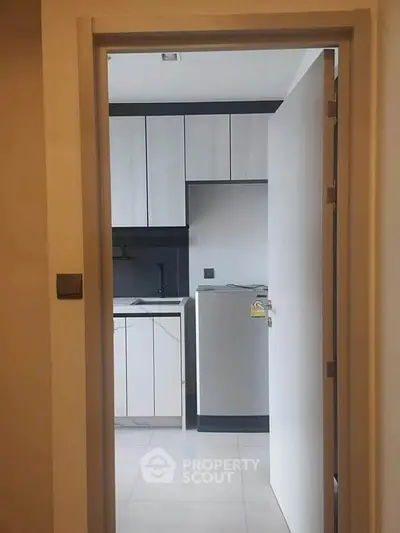 Modern kitchen with sleek cabinetry and stainless steel appliances in a contemporary apartment.