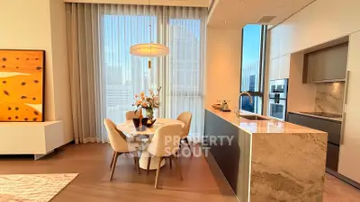Luxurious modern kitchen with marble island and dining area, featuring floor-to-ceiling windows and elegant decor.