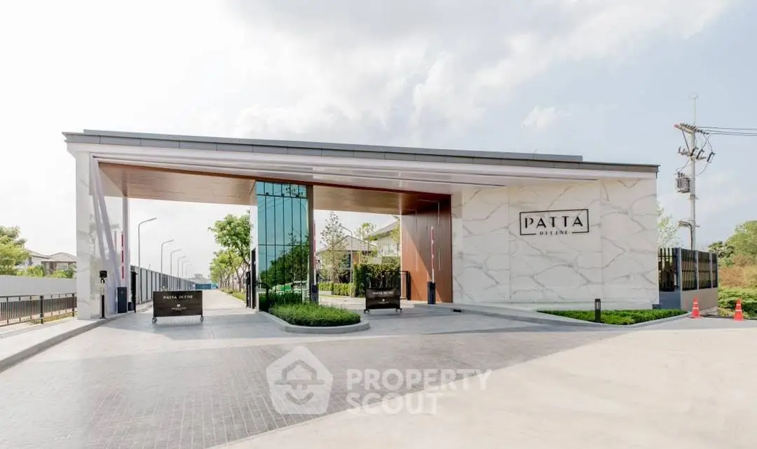 Elegant entrance of modern residential complex with sleek design and lush greenery.