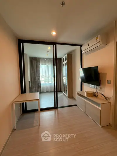Modern living room with glass partition and wall-mounted TV in a stylish apartment.