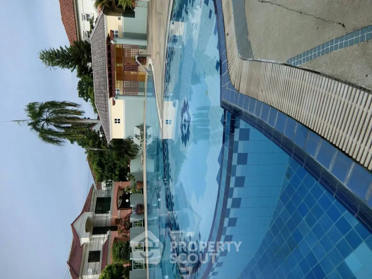 Luxurious residential pool area with modern design and lush greenery.