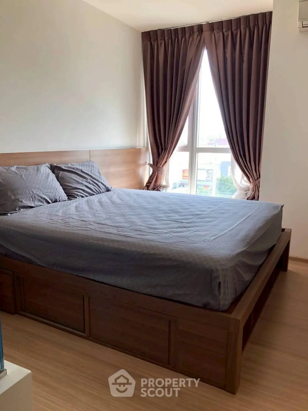 Cozy bedroom with elegant curtains and wooden bed frame, perfect for relaxation.