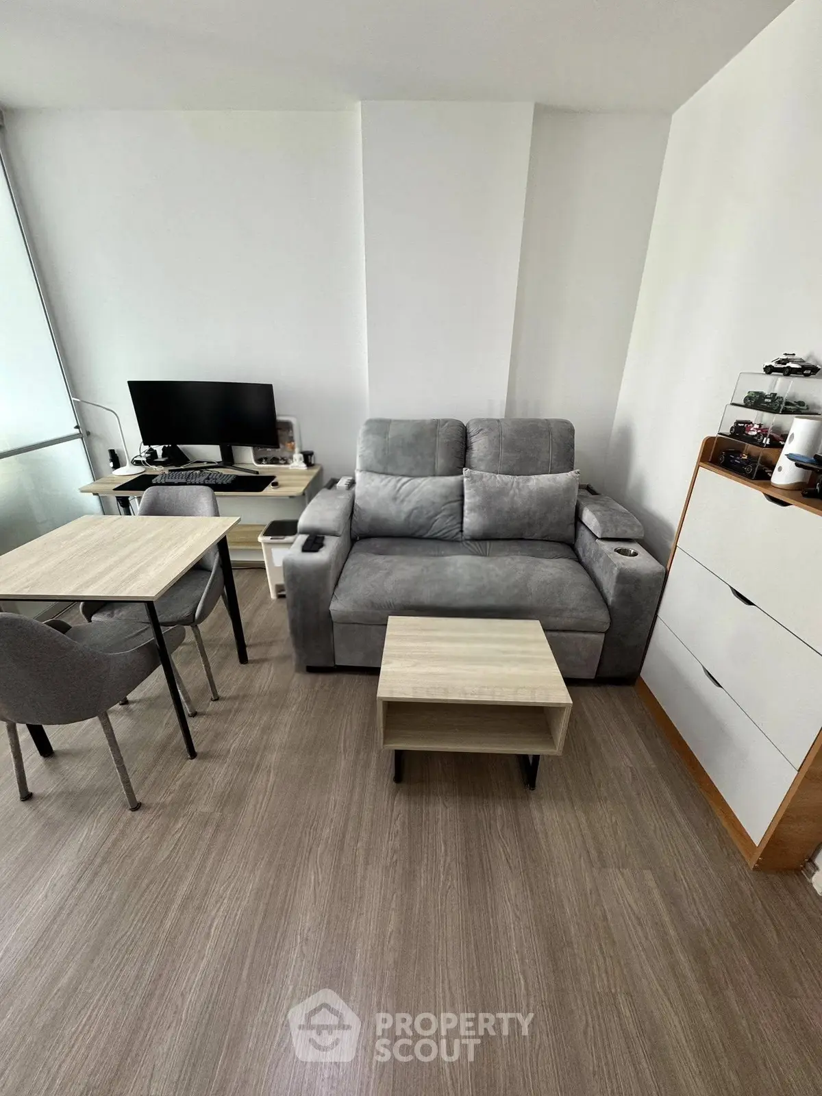 Modern living room with stylish furniture and workspace setup, perfect for urban living.