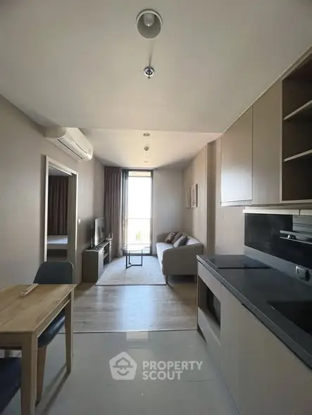 Modern open-plan living room and kitchen with sleek design and natural light.