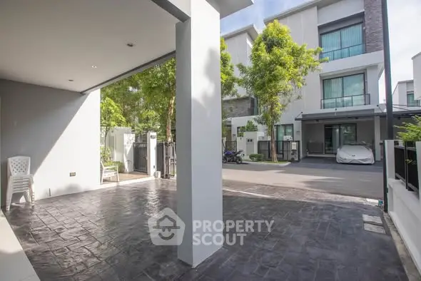 Modern townhouse exterior with spacious driveway and lush greenery