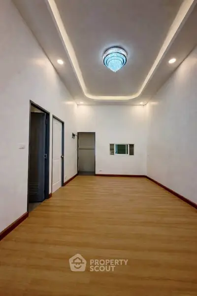 Spacious modern room with elegant ceiling lighting and wooden flooring