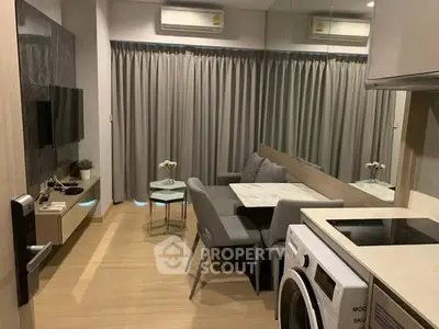Modern living room with dining area and washing machine, featuring sleek furniture and neutral tones.