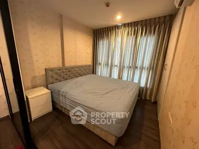 Cozy bedroom with elegant decor and natural light through large windows, perfect for relaxation.