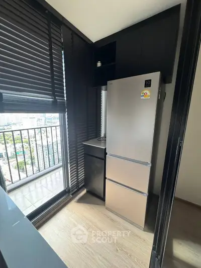 Modern kitchen with sleek fridge and city view from window
