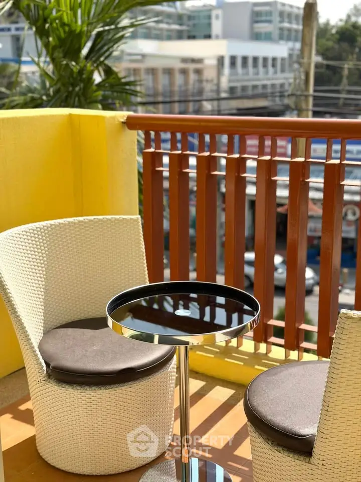 Charming balcony with cozy seating and vibrant city view, perfect for relaxation and enjoying the outdoors.