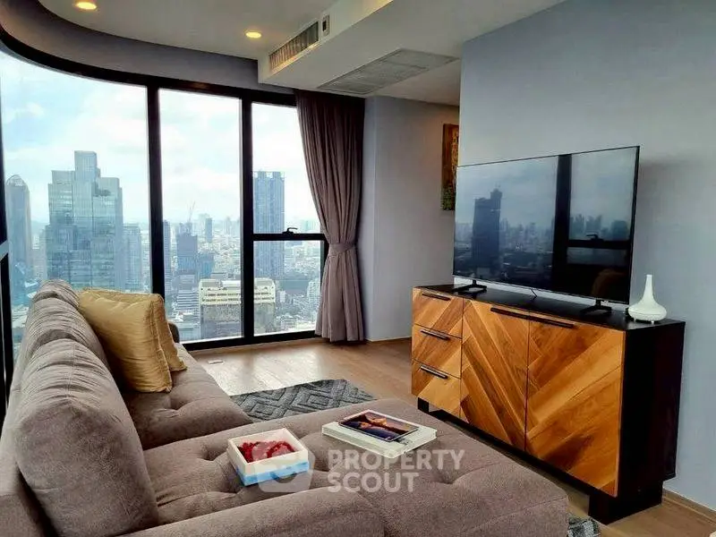 Modern living room with city view, stylish sofa, and sleek TV setup.