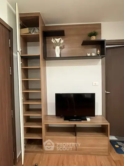Modern living room with sleek wooden furniture and built-in storage solutions.