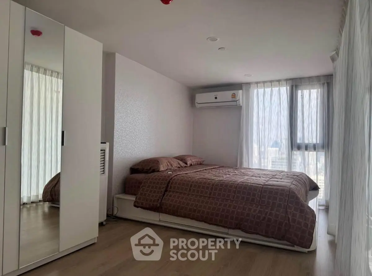 Modern bedroom with large windows and air conditioning in a stylish apartment.