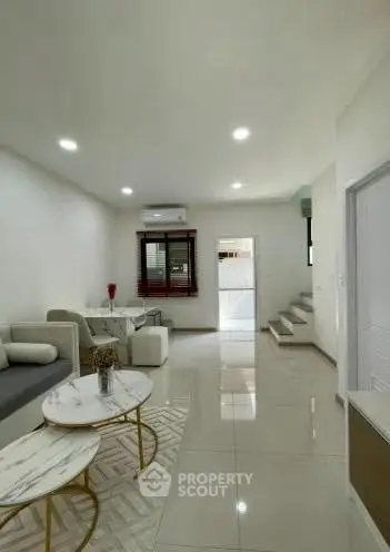 Modern living room with sleek design and natural light, featuring stylish furniture and open layout.