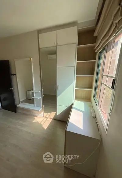 Bright bedroom with built-in wardrobe and large window for natural light