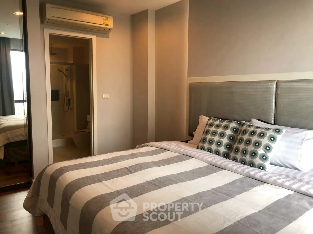 Modern bedroom with ensuite bathroom and stylish decor in a cozy apartment.