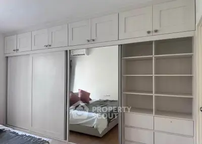 Spacious bedroom with built-in wardrobe and cozy bed setup.