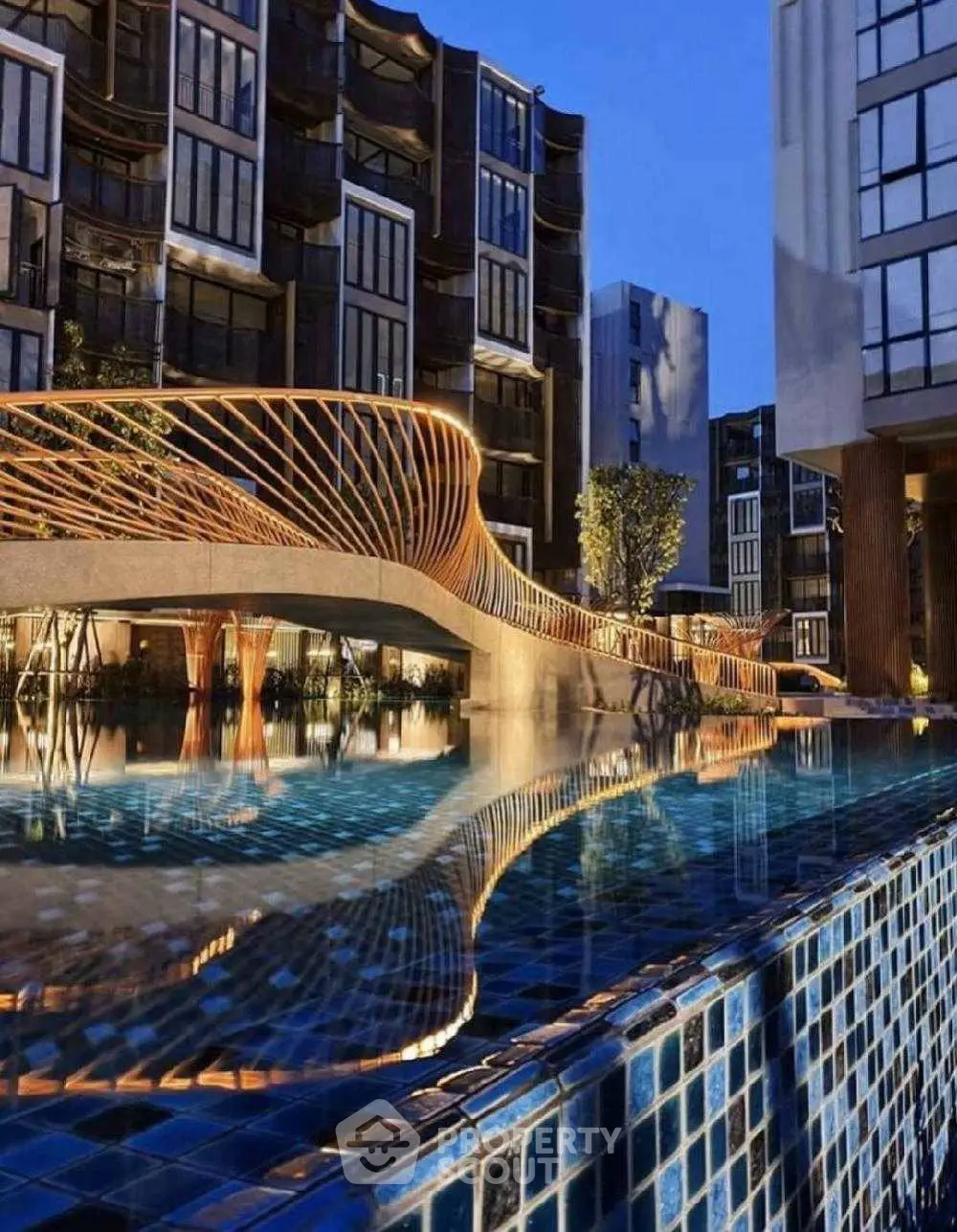 Luxurious modern building with stunning pool and architectural bridge at dusk.