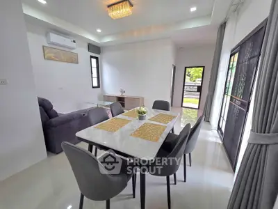 Modern dining area with elegant table and chairs, open layout, and natural light.