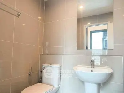 Modern bathroom with sleek fixtures and large mirror in a contemporary home.