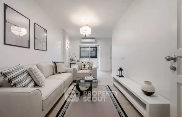 Modern living room with elegant decor and neutral tones, featuring a cozy sofa and stylish lighting.